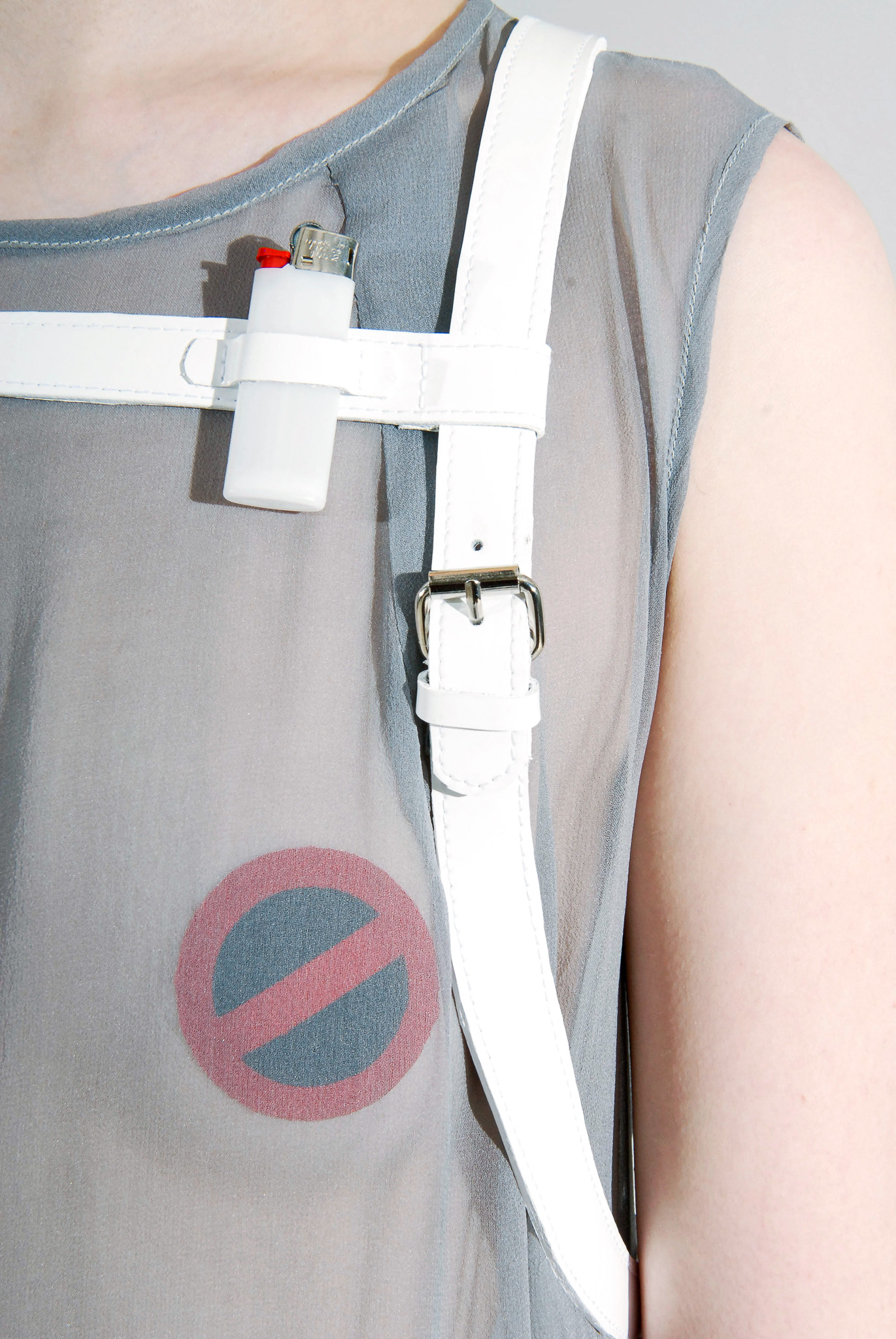 Detail of the cigarette-inspired printed shift dress and white harness construction from Look 02.
